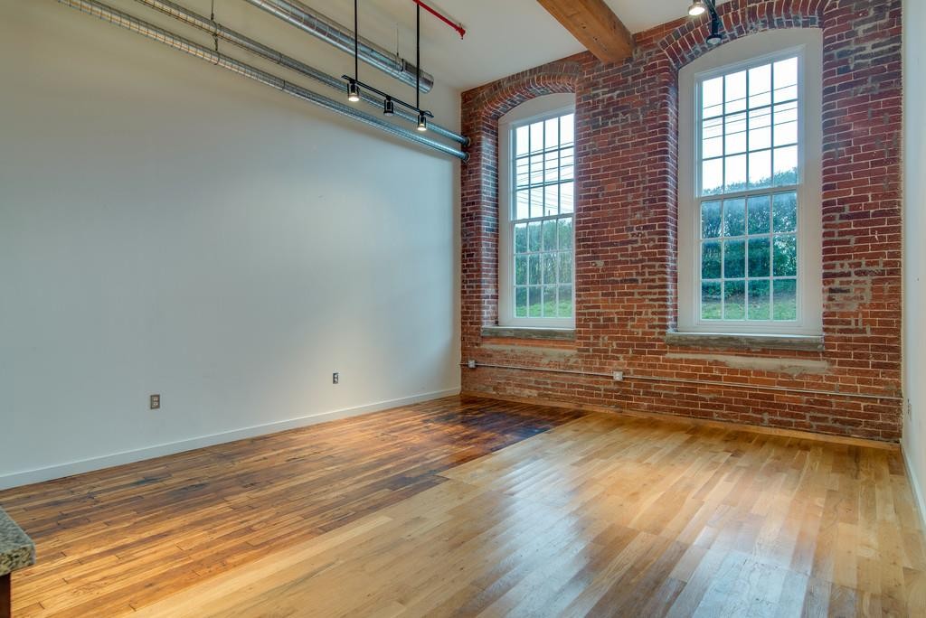 1350 Rosa L Parks Boulevard, Unit 239 Nashville, TN 37208 - Photo 3 of 23 an empty room with wooden floor and windows