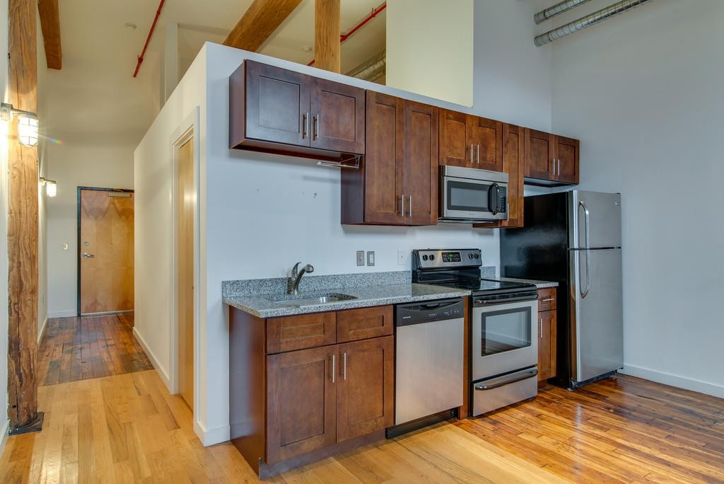 1350 Rosa L Parks Boulevard, Unit 239 Nashville, TN 37208 - Photo 10 of 23 a kitchen with stainless steel appliances granite countertop a stove a sink and a refrigerator