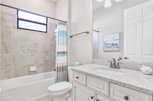 a bathroom with a granite countertop sink a toilet and a bathtub