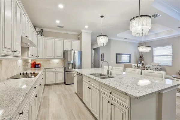 a kitchen with a sink dishwasher a stove a refrigerator and island with wooden floor