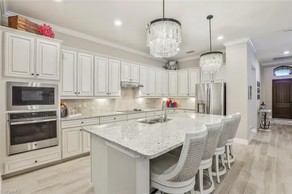 a kitchen with stainless steel appliances granite countertop a sink refrigerator and cabinets