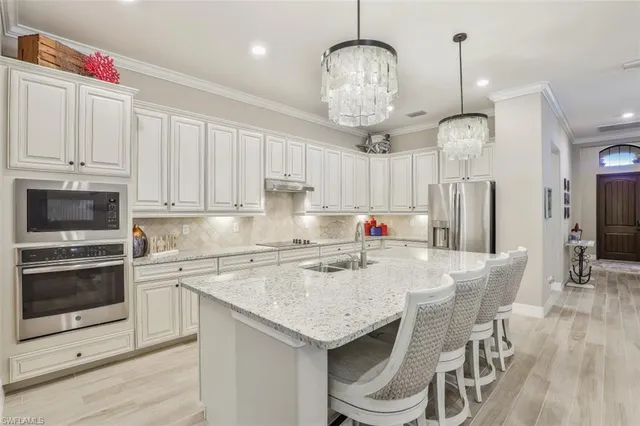 a kitchen with stainless steel appliances granite countertop a sink refrigerator and cabinets