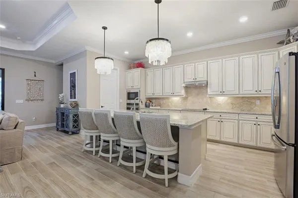 a kitchen with cabinets wooden floor dining table and chairs