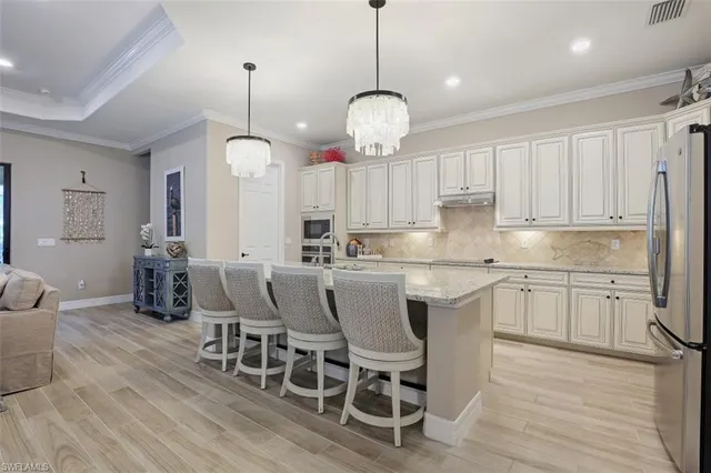a kitchen with cabinets wooden floor dining table and chairs