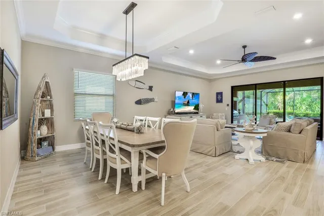 a dining room with wooden floor a chandelier a wooden table and chairs