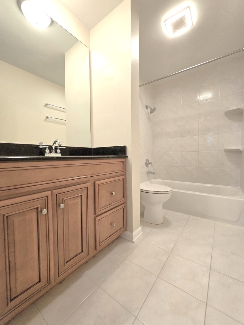 4946 Somerton Drive Hoffman Estates, IL 60010 - Photo 24 of 32 a bathroom with a granite countertop sink a toilet and shower