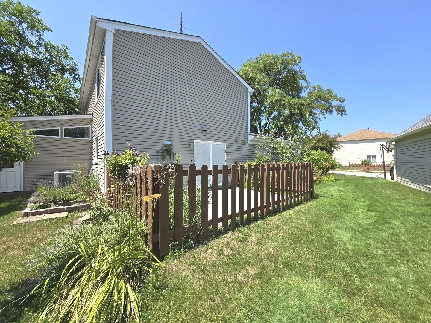 4946 Somerton Drive Hoffman Estates, IL 60010 - Photo 30 of 32 a view of a house with a small yard and plants