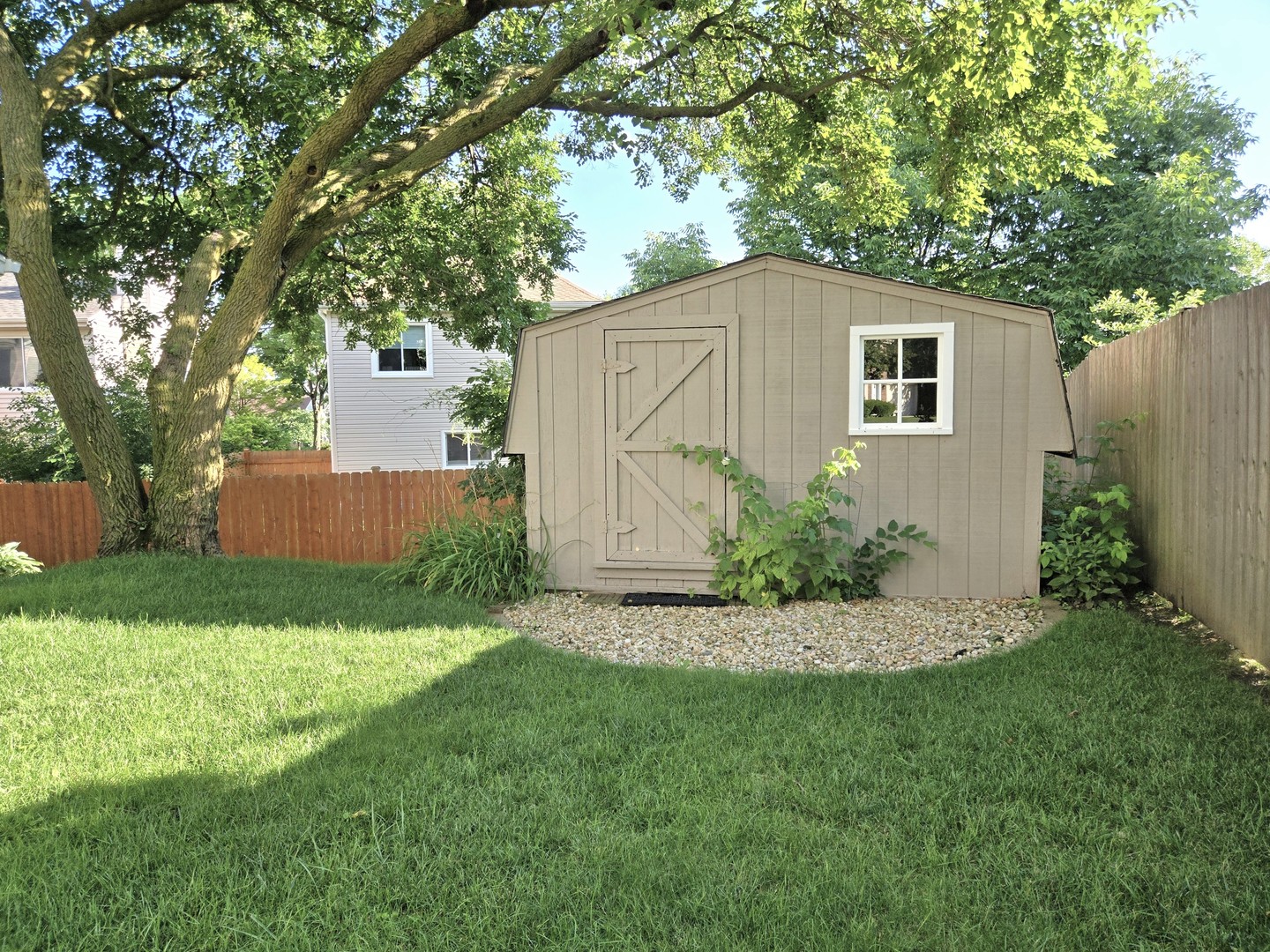 4946 Somerton Drive Hoffman Estates, IL 60010 - Photo 32 of 32 a backyard of a house with plants and large tree