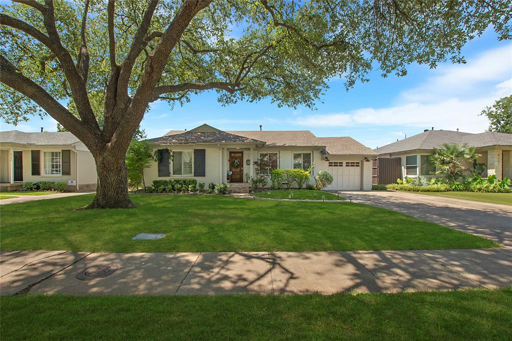 Ranch-style house featuring a garage, concrete driveway, and a front lawn