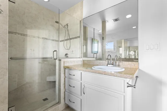 a bathroom with a sink a mirror and shower