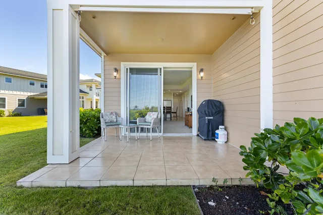 a view of a swimming pool with chairs and table in a patio