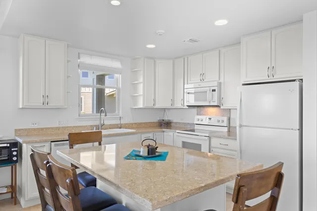 a kitchen with refrigerator and white cabinets