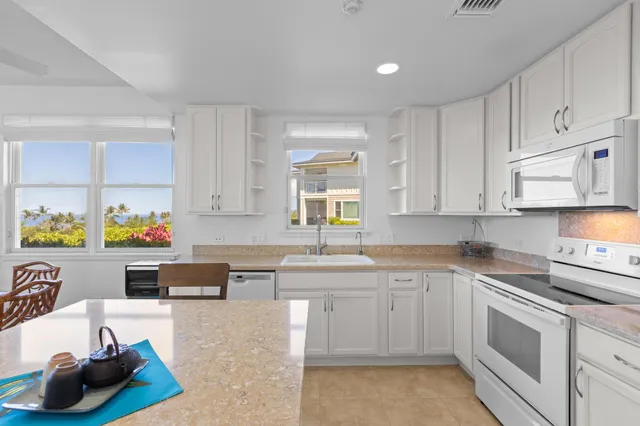 a dining room with stainless steel appliances kitchen island granite countertop a dining table and chairs