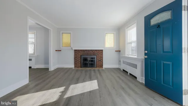 an empty room with wooden floor windows and fireplace