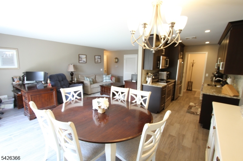70 Harristown Road, Unit 3 Fair Lawn, NJ 07410 - Photo 11 of 20 a living room with furniture a flat screen tv and kitchen view