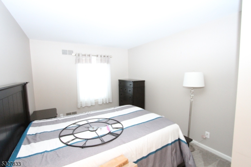 70 Harristown Road, Unit 3 Fair Lawn, NJ 07410 - Photo 18 of 20 a bedroom with a bed and a chandelier