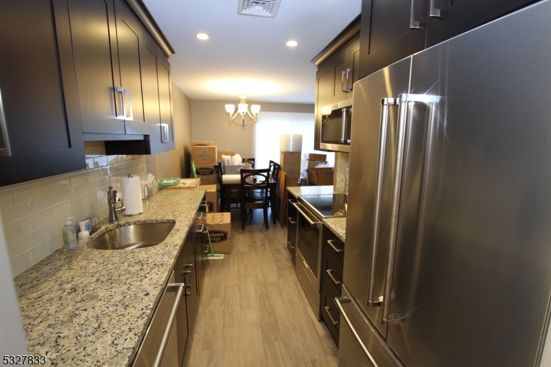 70 Harristown Road, Unit 3 Fair Lawn, NJ 07410 - Photo 6 of 20 a kitchen with counter top space a sink a refrigerator and wooden cabinets