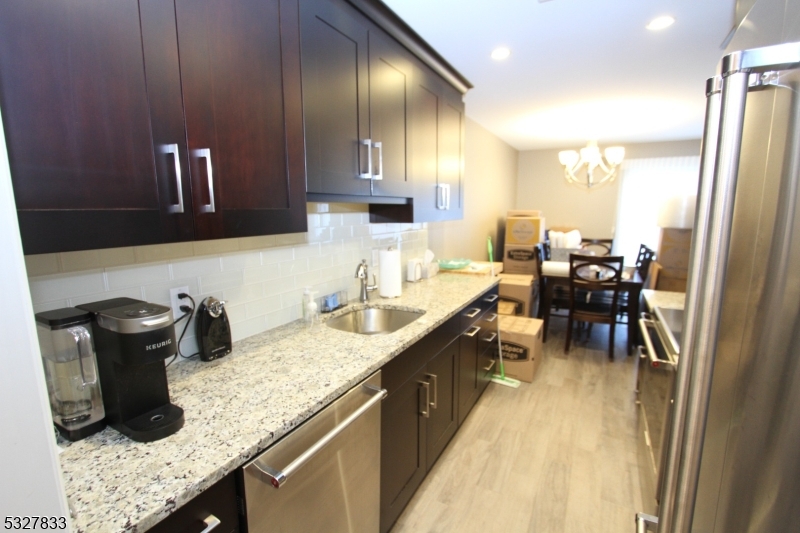 70 Harristown Road, Unit 3 Fair Lawn, NJ 07410 - Photo 7 of 20 a kitchen with granite countertop kitchen island stainless steel appliances a sink a counter top space and cabinets