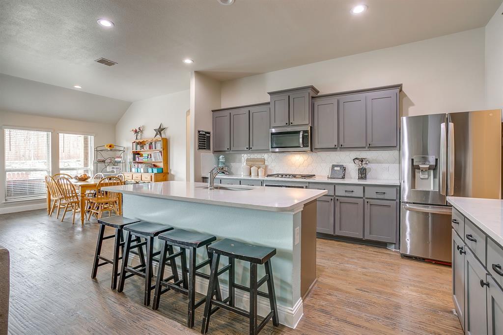 15141 Fleet Hill Road Aledo, TX 76008 - Photo 7 of 37 a kitchen with a table chairs microwave and cabinets