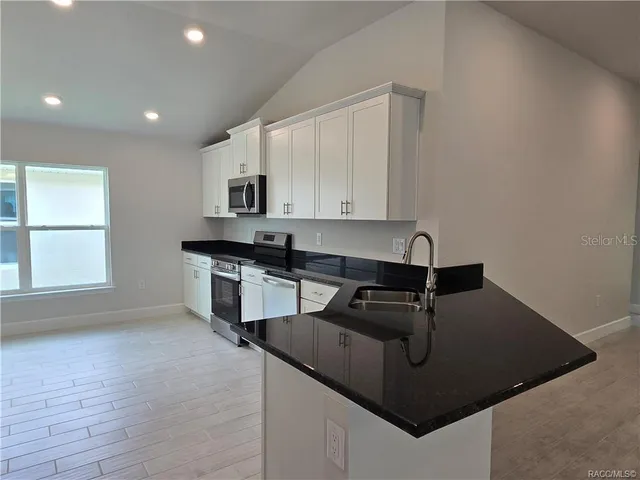 a kitchen with kitchen island a sink stove and microwave