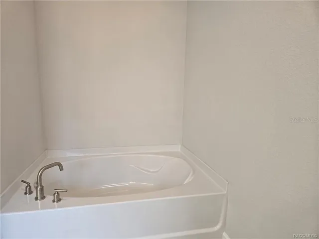 a white bath tub sitting next to a white sink and vanity