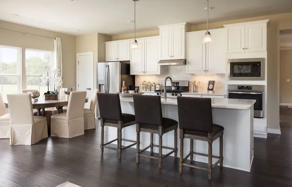 a view of kitchen with stainless steel appliances granite countertop a stove a sink a refrigerator dining table and chairs