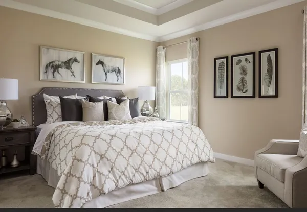 a bedroom with a large bed and painting on the wall