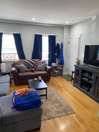 26 Maverick Street, Unit 1 Boston, MA 02128 - Photo 4 of 8 a living room with furniture a flat screen tv and a large window