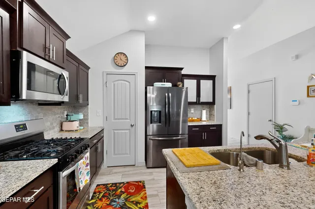 a kitchen with stainless steel appliances granite countertop a refrigerator stove and sink