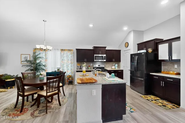 a kitchen with a refrigerator and a dining table