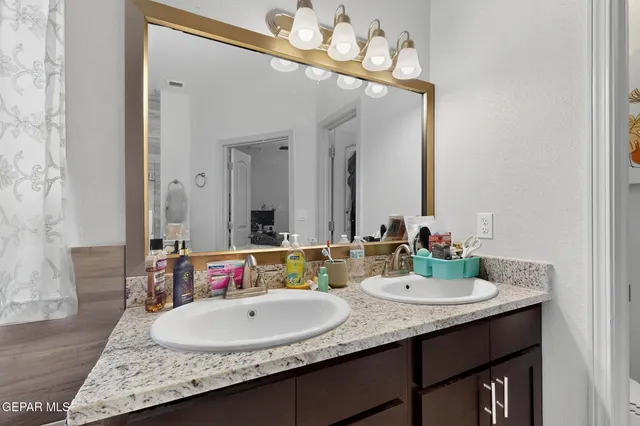a bathroom with a granite countertop sink and a mirror