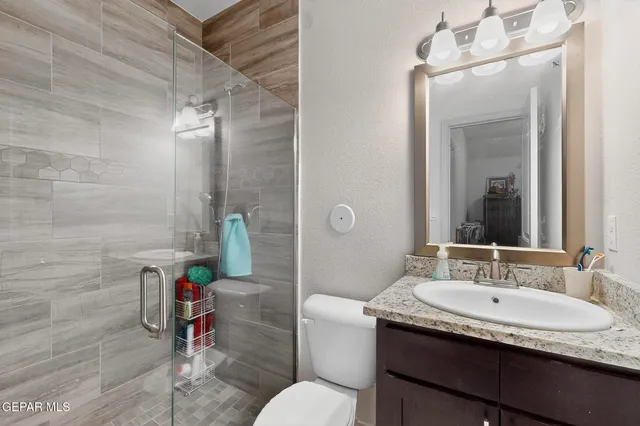 a bathroom with a granite countertop sink a toilet and a mirror