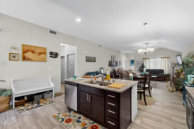 a open kitchen with stainless steel appliances granite countertop a stove a refrigerator a dining table and chairs with wooden floor