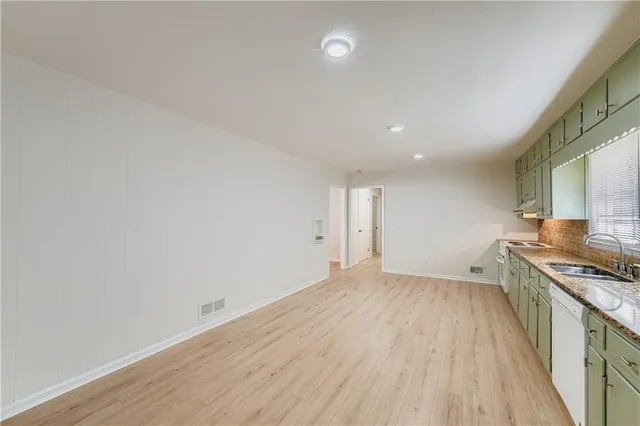 a view of a kitchen with wooden floor and stainless steel appliances