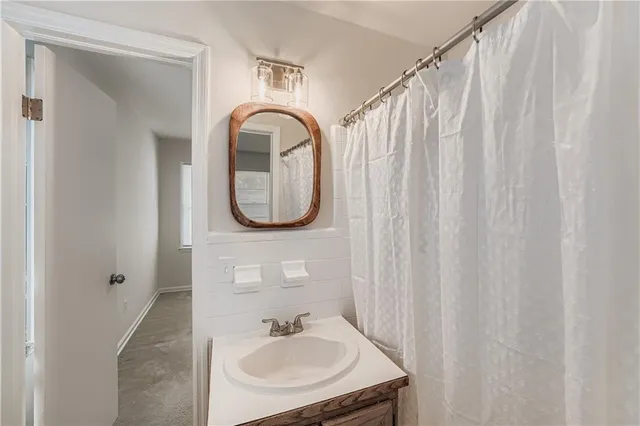 a bathroom with a sink a mirror and a shower curtain