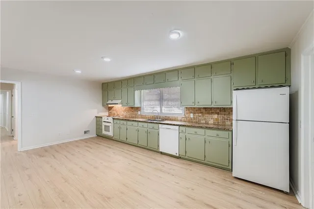 a kitchen with a sink cabinets and wooden floor