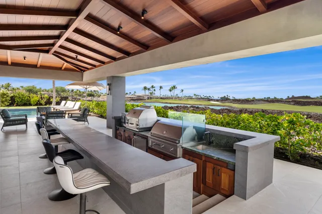 a view of a swimming pool with a table and chairs under an umbrella