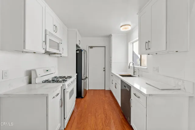 a kitchen with stainless steel appliances granite countertop a sink stove and refrigerator