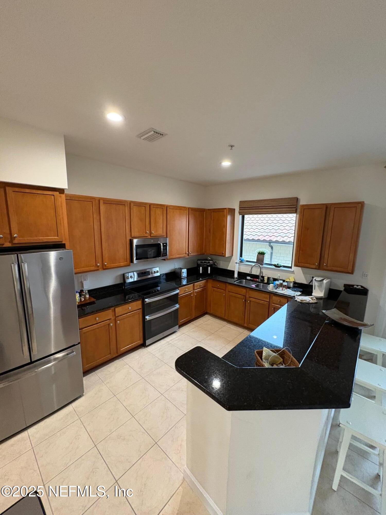 544 Market Street St. Augustine, FL 32095 - Photo 6 of 17 a kitchen with stainless steel appliances granite countertop a sink stove and refrigerator
