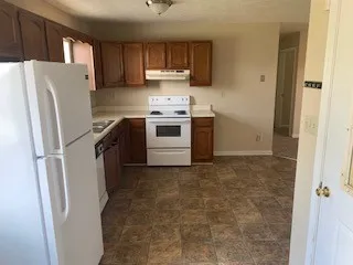 a kitchen with a refrigerator sink and cabinets