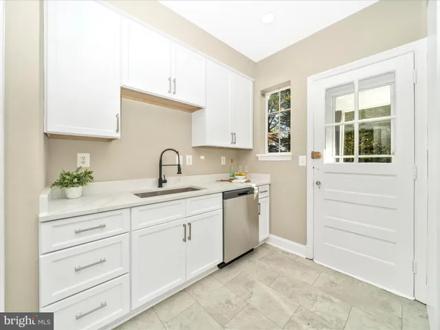 a kitchen with a refrigerator a sink and a stove top oven