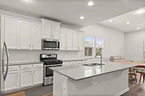 a kitchen with a sink appliances and cabinets