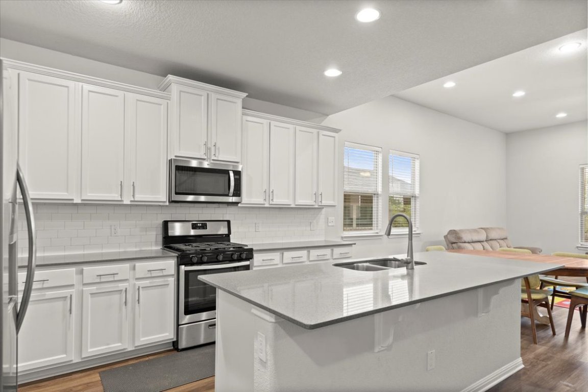 213 Munk Lane Leander, TX 78641 - Photo 11 of 40 a kitchen with stainless steel appliances granite countertop a sink a stove and a refrigerator