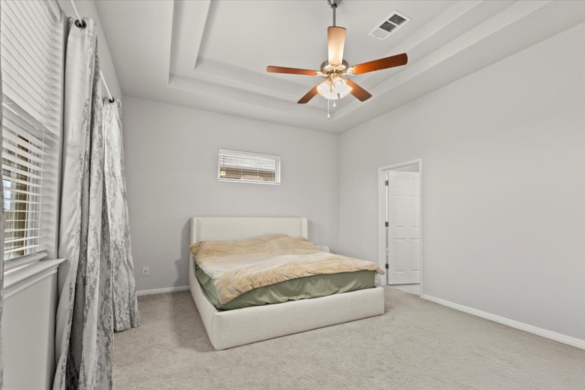213 Munk Lane Leander, TX 78641 - Photo 16 of 40 a bedroom with a bed and a chandelier