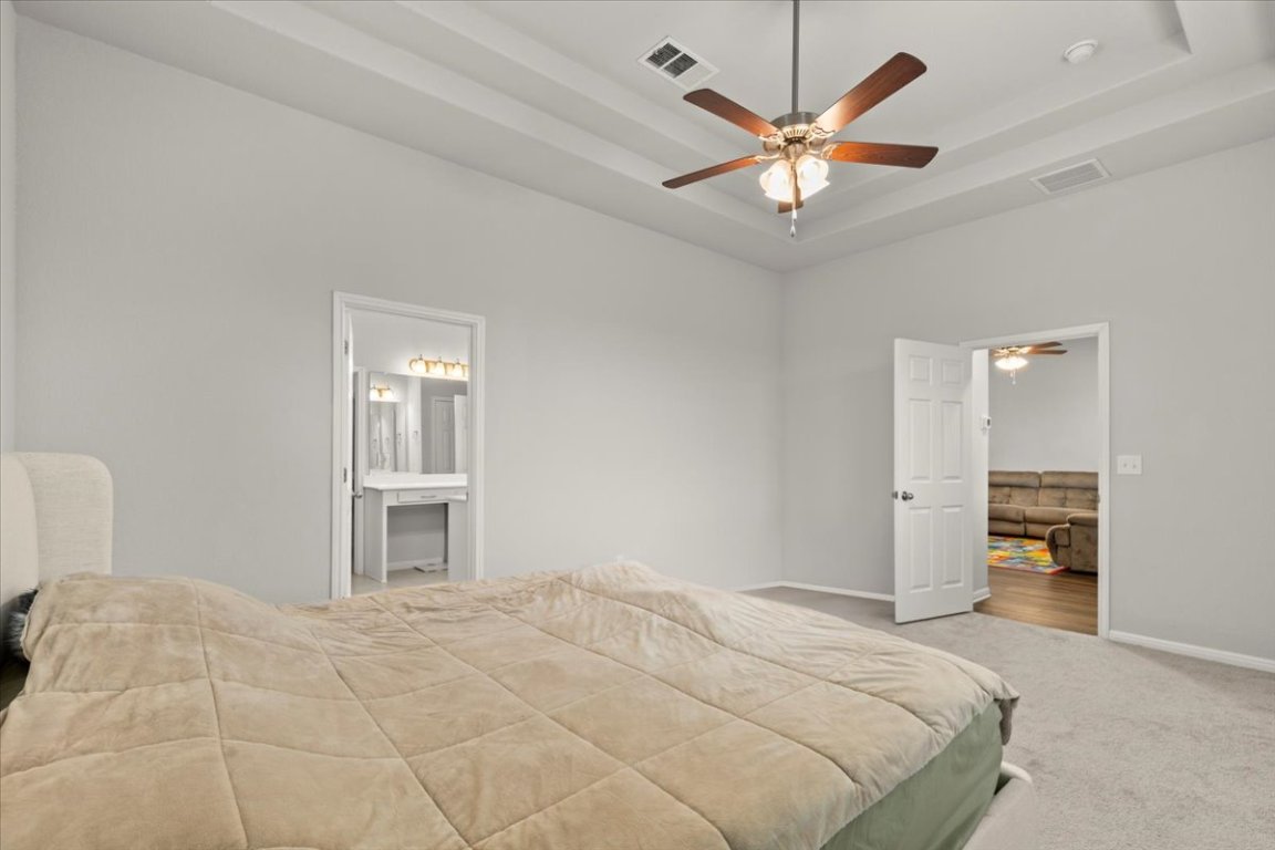 213 Munk Lane Leander, TX 78641 - Photo 17 of 40 a bedroom with a large bed and a ceiling fan
