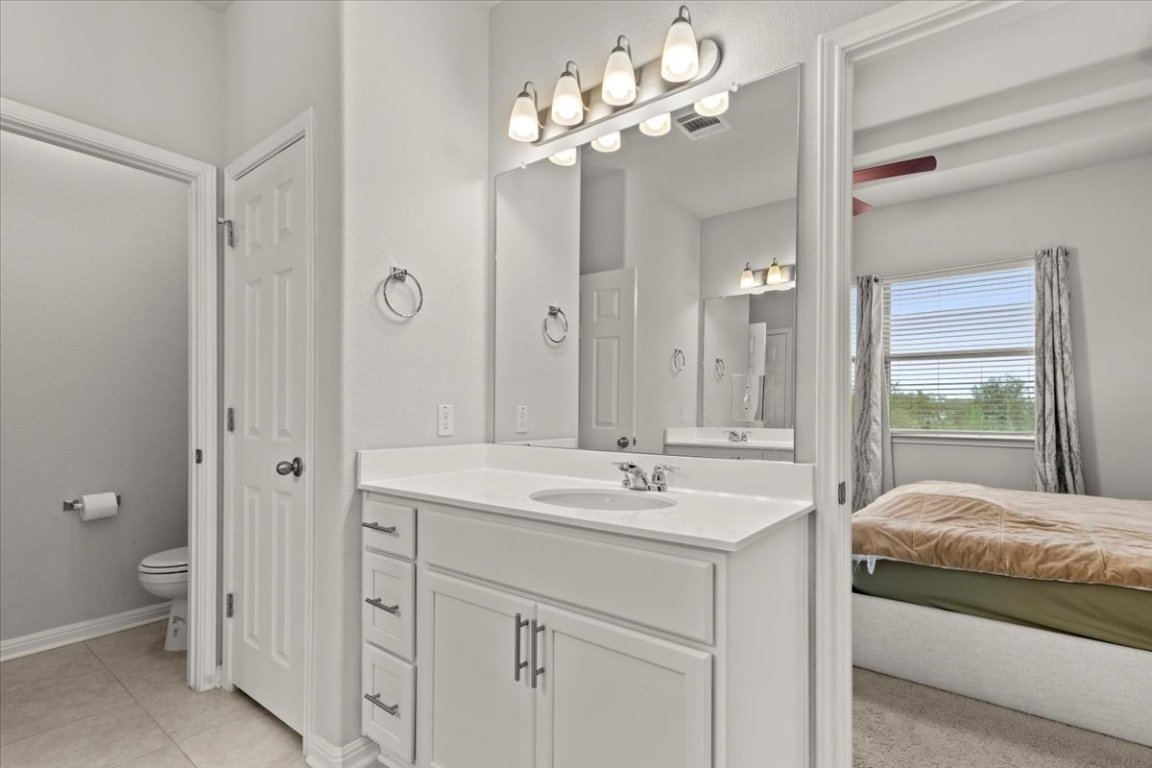 213 Munk Lane Leander, TX 78641 - Photo 18 of 40 a spacious en suite bathroom with a granite countertop sink a toilet and a mirror