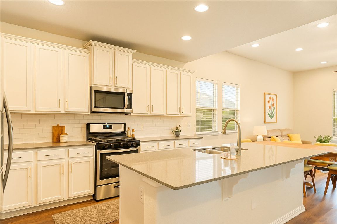 213 Munk Lane Leander, TX 78641 - Photo 2 of 40 a kitchen with stainless steel appliances granite countertop a sink stove and cabinets