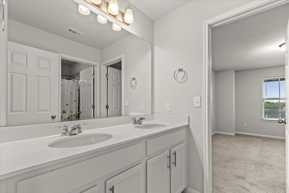213 Munk Lane Leander, TX 78641 - Photo 30 of 40 a bathroom with a sink double vanity and a mirror