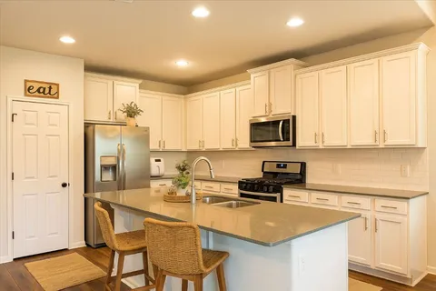 a kitchen with stainless steel appliances granite countertop a sink stove and cabinets