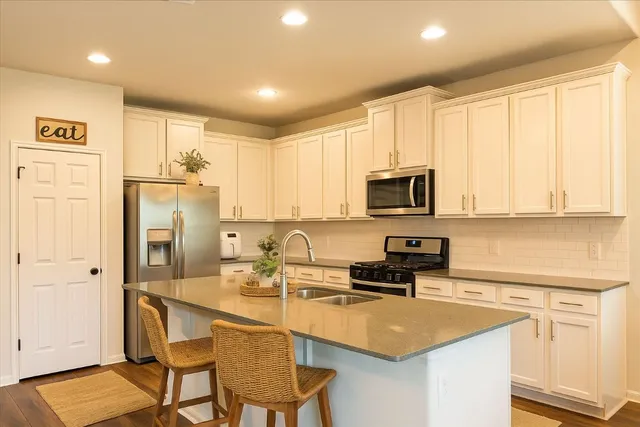 a kitchen with stainless steel appliances granite countertop a sink stove and cabinets